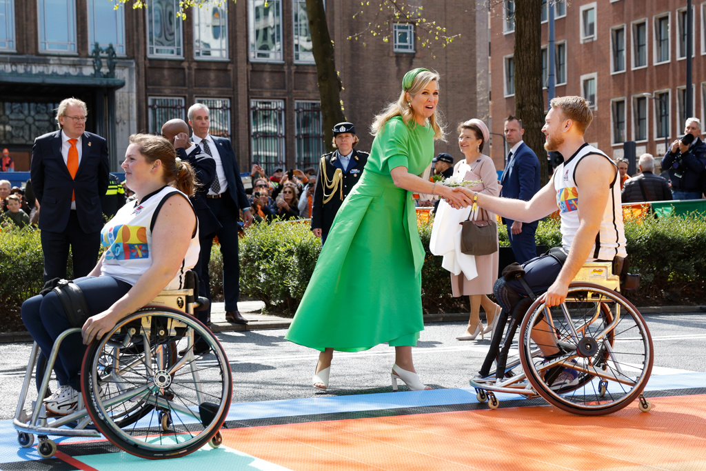 Foto van koningin Maxima die een hand geeft aan een basketbal speler in een rolstoel.   Foto van koningin Maxima die een hand geeft aan een basketbal speler in een rolstoel.